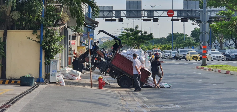  Xe 3 bánh chở vật liệu xây dựng nhổng bánh trên lòng lề đường Võ Văn Kiệt, quận 5, TPHCM