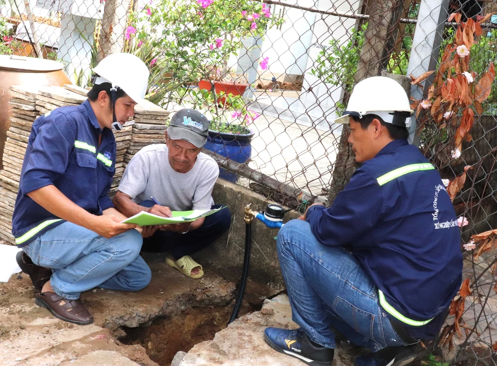 Ông Nguyễn Văn Tới (giữa), ngụ tổ 4, ấp An Hòa, xã Tam Thôn Hiệp (huyện Cần Giờ) ký nhận đồng hồ nước vừa được lắp đặt từ Xí nghiệp Cấp nước Cần Giờ