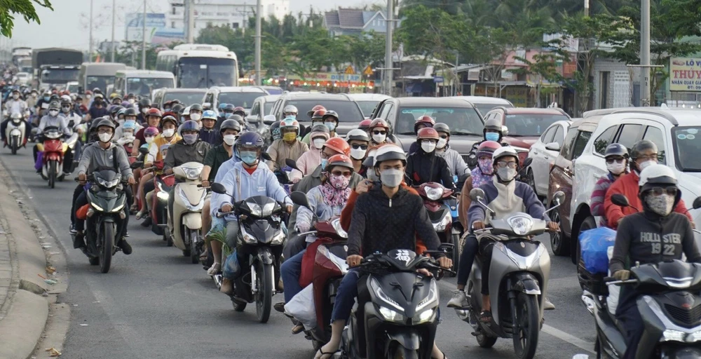 Dòng xe di chuyển chậm trên quốc lộ 60 (huyện Châu Thành, tỉnh Bến Tre) đoạn dẫn vào cầu Rạch Miễu. Ảnh: TÍN HUY