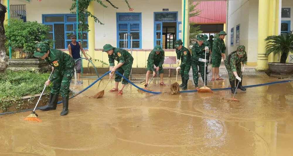 Cán bộ, chiến sĩ Bộ đội Biên phòng tỉnh Quảng Bình tham gia vệ sinh trường học sau lũ tại huyện Lệ Thủy