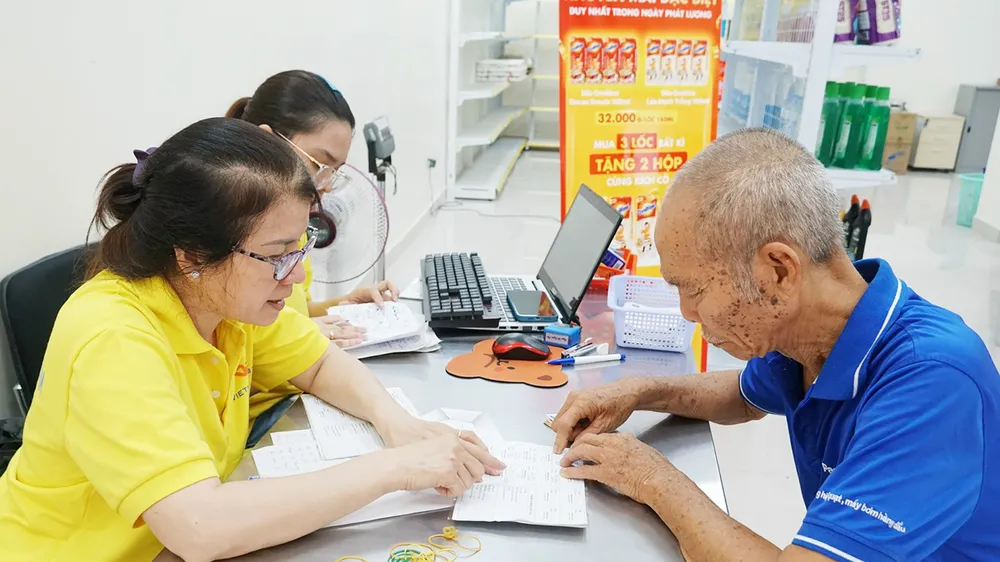 Nhân viên Bưu điện TPHCM chi trả lương hưu, trợ cấp BHXH đến người dân. Ảnh: ĐÔNG SƠN E4a.jpg