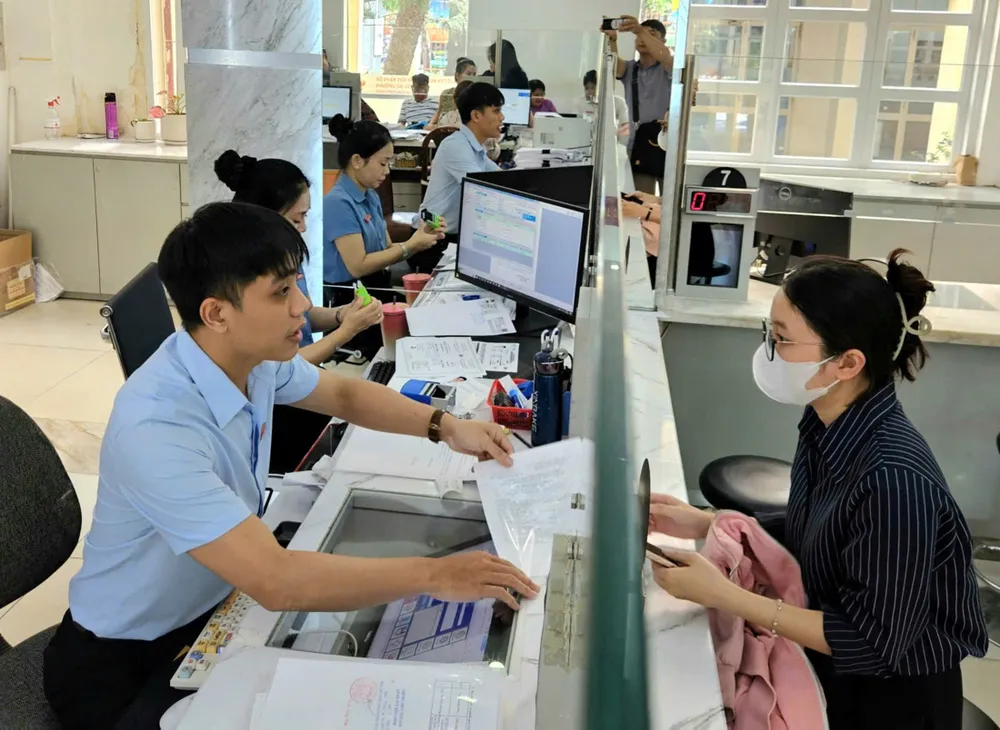 ông chức Trung tâm Phục vụ hành chính công phường Sài Gòn, TPHCM tiếp nhận, giải quyết hồ sơ cho người dân. Ảnh: NGÔ BÌNH A1e.jpg