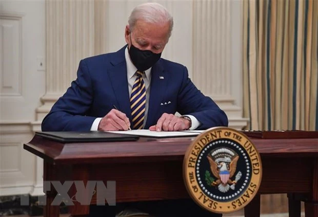 Tổng thống Mỹ Joe Biden ký sắc lệnh tại Nhà Trắng ở Washington DC. (Ảnh: AFP/TTXVN)