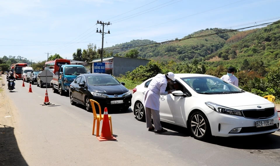 Nhân viên y tế kiểm dịch ở cửa ngõ trên quốc lộ 20 từ TP HCM về Đà Lạt đầu năm 2021. Ảnh: Khánh Phúc