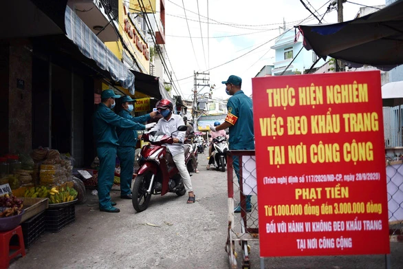 Người dân được đo thân nhiệt trước khi vào mua sắm tại chợ Nguyễn Đình Chiểu, Q.Phú Nhuận, TPHCM. Ảnh: NGỌC PHƯỢNG