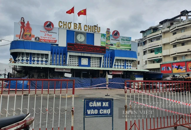 Chợ Bà Chiểu căng dây tứ phía nhưng vẫn còn hoạt động với một lối vào, siết chặt phòng dịch. Ảnh: Hồng Phúc.