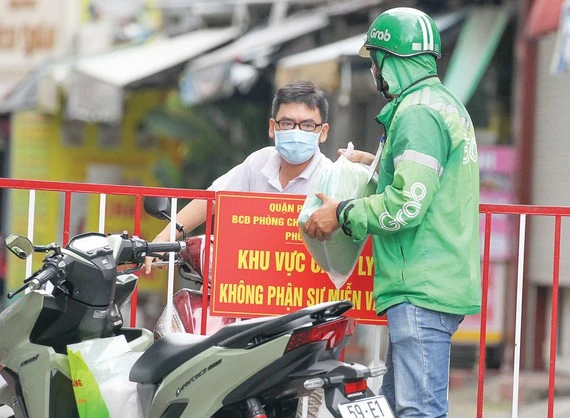 Shipper giao hàng cho khách trên đường Hoàng Văn Thụ, quận Phú Nhuận, TPHCM trưa 31-8. Ảnh: Hoàng Hùng. 