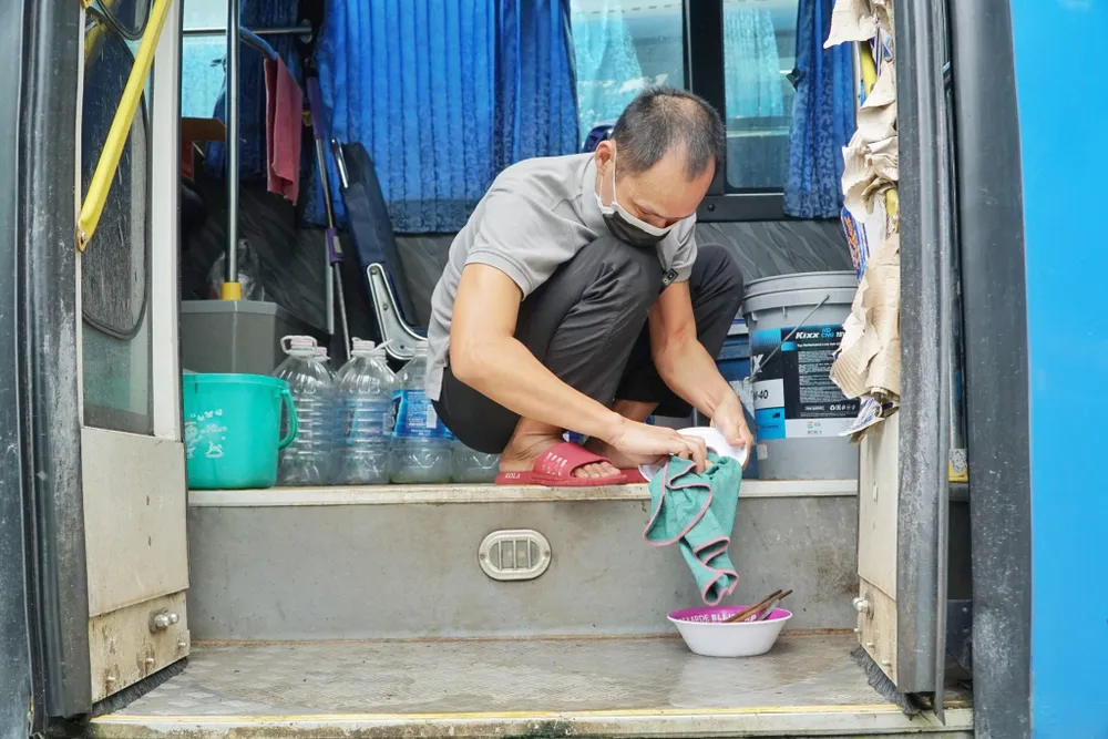 Anh Cường rửa chén và tắm cũng trên xe. Ảnh: Lê Hồng Hạnh. Tài xế, tiếp viên không tiền ăn ngủ trên xe buýt 'nằm im' suốt mùa dịch Covid-19 - ảnh 5