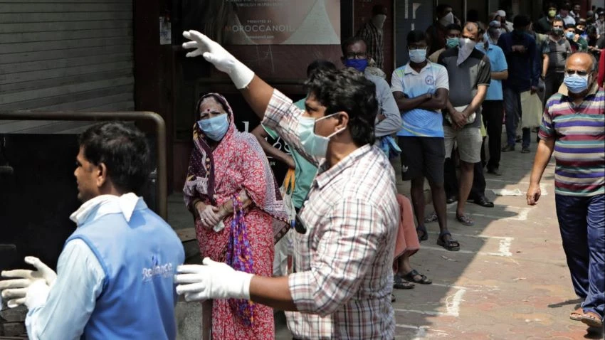 Shoppers wait for their turn to enter a grocery store in Mumbai on March 26. The nationwide lockdown has squeezed the supply of essential items such as food and medication. © AP