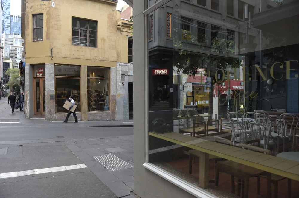 Chairs sit stacked on tables in a closed cafe during coronavirus lockdown in Melbourne on March 23. Photographer: Carla Gottgens/Bloomberg