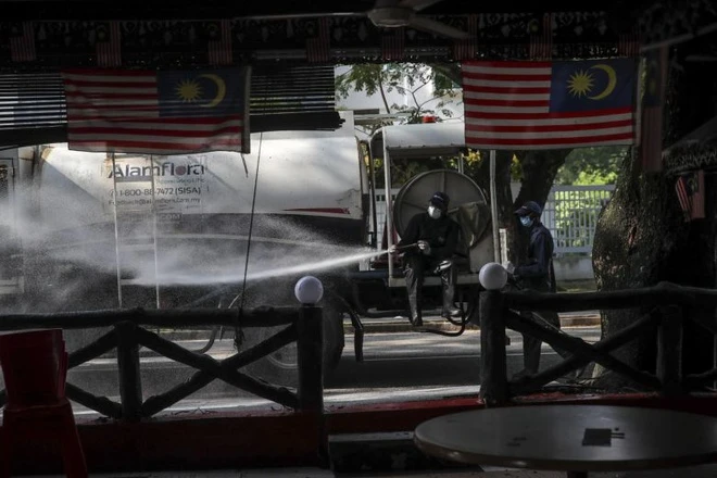 Nhân viên y tế tẩy trang khu vực quanh nhà thờ Sri Petaling. Ảnh: Straits Times.