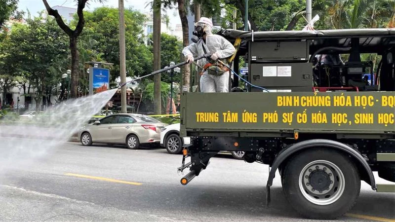 Phun thuốc khử trùng trên đường phố ở Hà Nội - Ảnh: Reuters