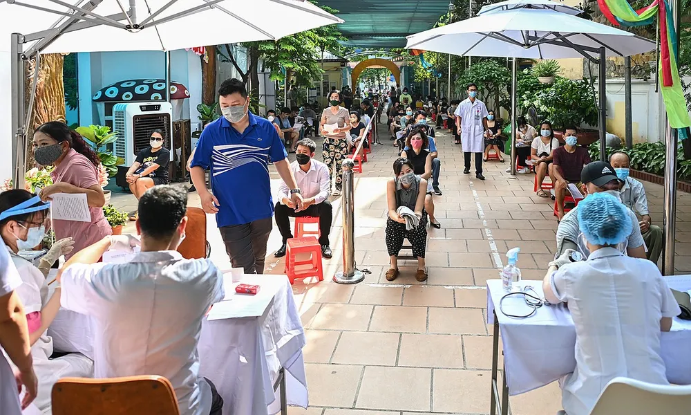 People at a Covid-19 vaccination station in Hanoi in July, 2021. Photo by VnExpress/Giang Huy