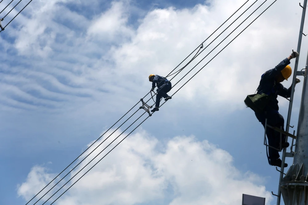 Công nhân vận hành lưới điện Trung Quốc Southern Power Grid kiểm tra cáp điện. Ảnh: Reuters.