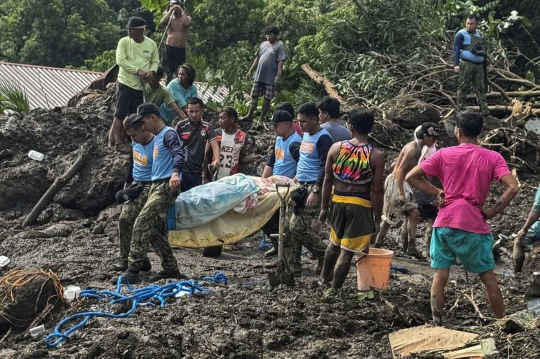 Nhân viên cứu hộ và người dân khiêng một nạn nhân của trận lở đất ở tỉnh Batangas do Bão nhiệt đới Trami gây ra, ngày 25/10/2024 [Jay Ereno/Reuters]