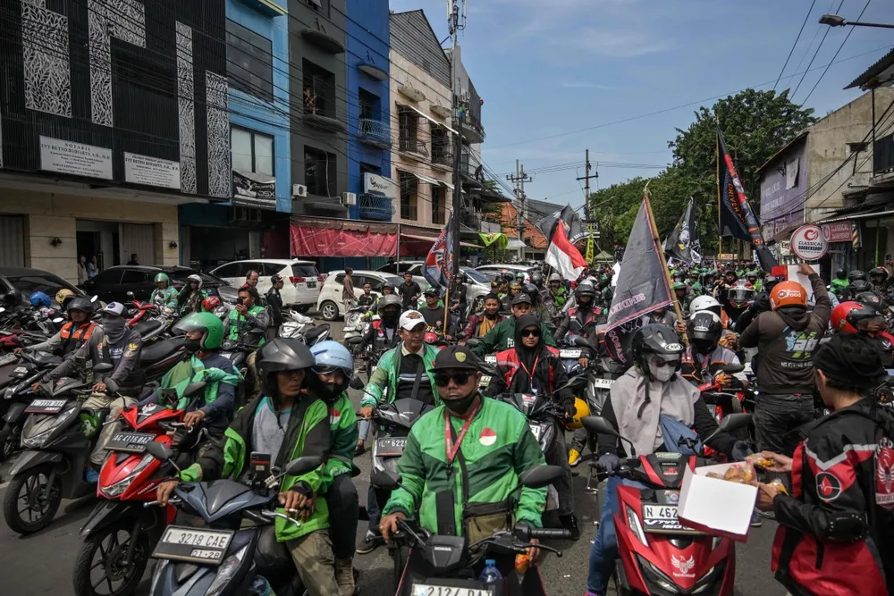 Tài xế của các nền tảng gọi xe biểu tình bên ngoài văn phòng Gojek tại Surabaya vào ngày 20/5/2025. (Ảnh của JUNI KRISWANTO)
