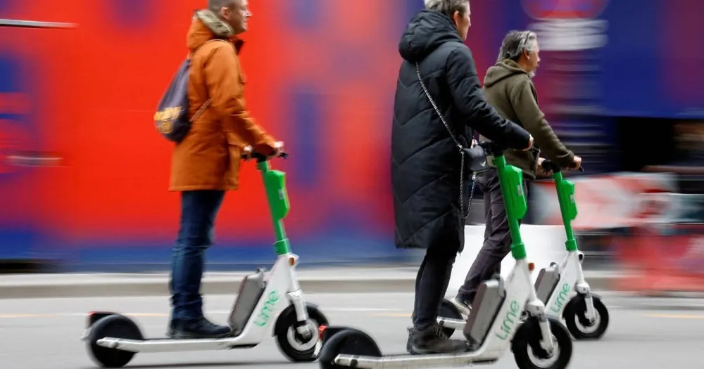 Người dân đi xe tay ga điện của dịch vụ chia sẻ Lime tại Paris, Pháp