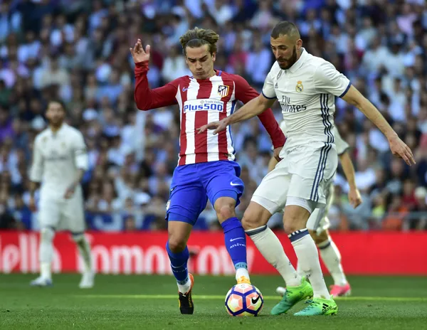 Griezmann (trái) tranh bóng với Benzema.