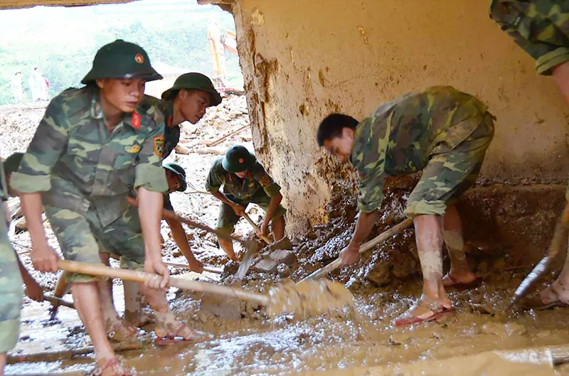 Bộ đội giúp người dân khắc phục mưa lũ Ảnh: VĂN CHƯƠNG