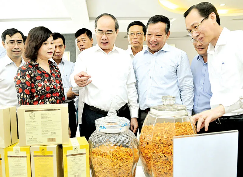 Bí thư Thành ủy TPHCM Nguyễn Thiện Nhân xem sản phẩm nông nghiệp công nghệ cao Ảnh: CAO THĂNG