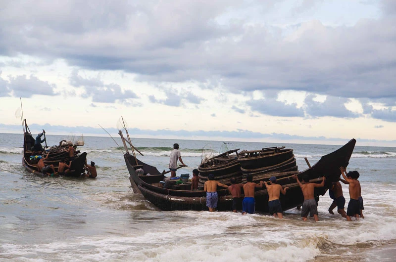 Ngư dân đẩy thuyền ra khơi sau cơn bão vừa tan