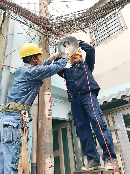 Đoàn viên thanh niên ngành điện thi công lắp mới đèn chiếu sáng tuyến hẻm