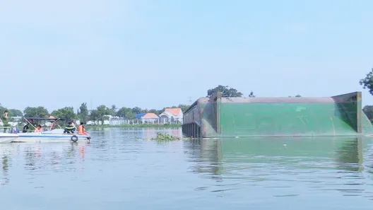 Lực lượng tìm kiếm xung quanh chiếc sà lan bị lật úp đề tìm người mất tích dưới sông. Ảnh: TTXVN