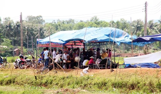 Người dân thôn Châu Trúc dựng rạp canh giữ 3 ô tô (trong đó 2 xe công vụ) để mong được đối thoại với lãnh đạo tỉnh Bình Định về dự án điện mặt trời, vào tháng 7-2018. 