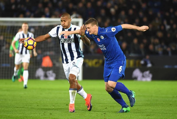 Robert Huth (phải, Leicester) tranh bóng với Salomon Rondon (West Brom).