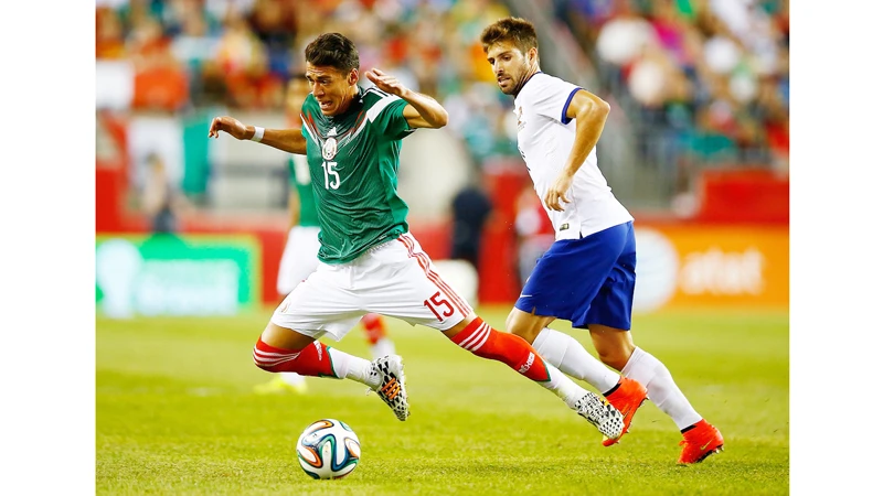 Miguel Veloso (phải, Bồ Đào Nha) phạm lỗi với Hector Moreno (Mexico).