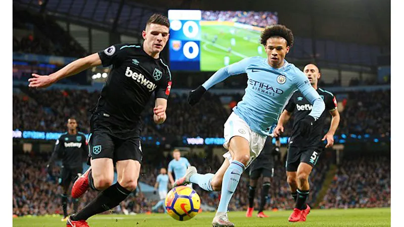 Declan Rice (trái, West Ham) đi bóng trước Leroy Sane của Manchester City