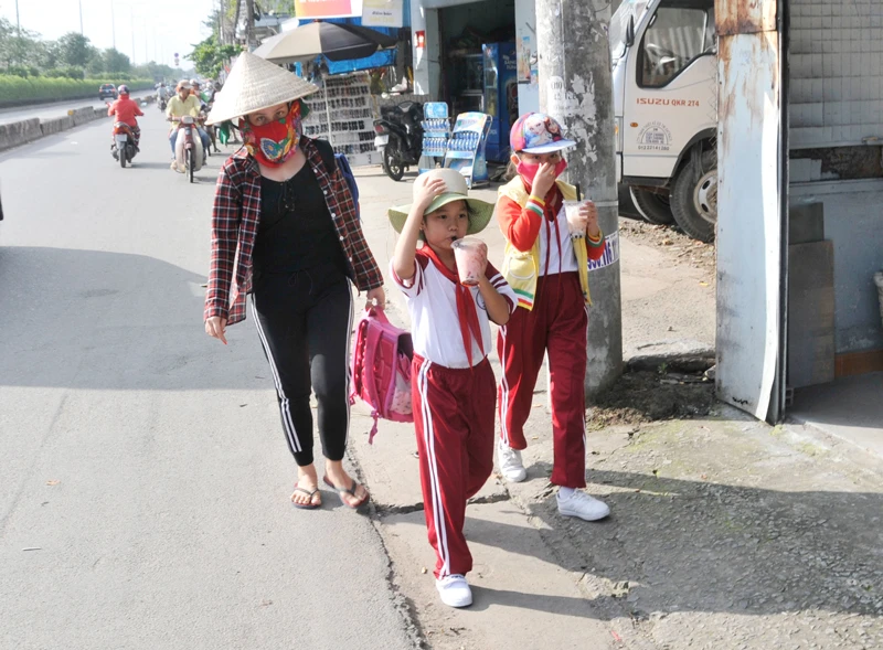 Học sinh một trường tiểu học ở huyện Hóc Môn trên đường về nhà sau giờ tan trường. Ảnh: THÀNH TRÍ