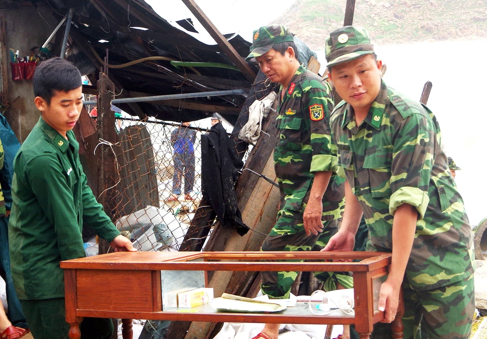 Chiến sĩ bộ đội biên phòng tỉnh Bình Định hỗ trợ người dân khắc phục hậu quả sau bão. Ảnh: XUÂN HUYÊN