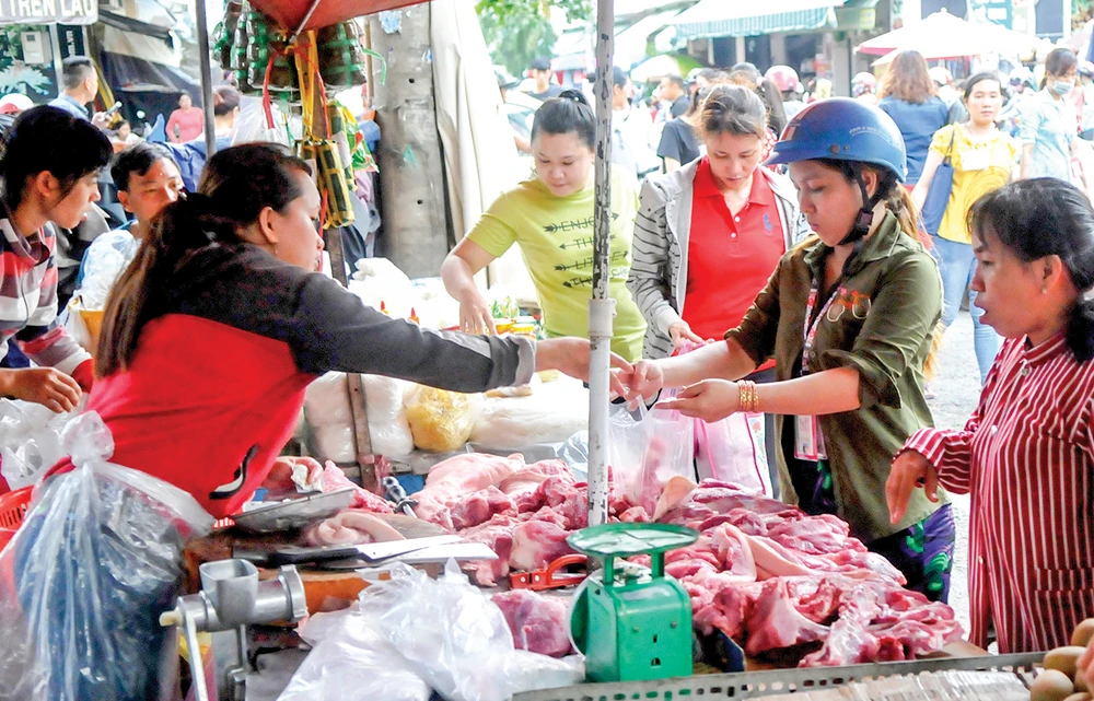 Người tiêu dùng chọn mua thịt heo tại một chợ ở TPHCM. Ảnh: ĐỨC THIỆN