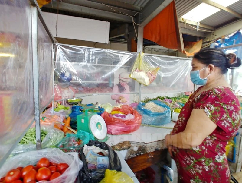 Tiểu thương bán hàng ở chợ truyền thống làm vách ngăn bảo đảm điều kiện an toàn phòng chống dịch. Ảnh: hcmcpv