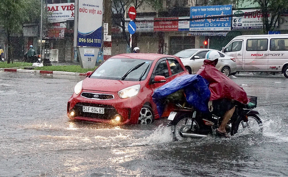 Mưa lớn, triều cường làm ngập đường, gây khó khăn cho sinh hoạt của người dân