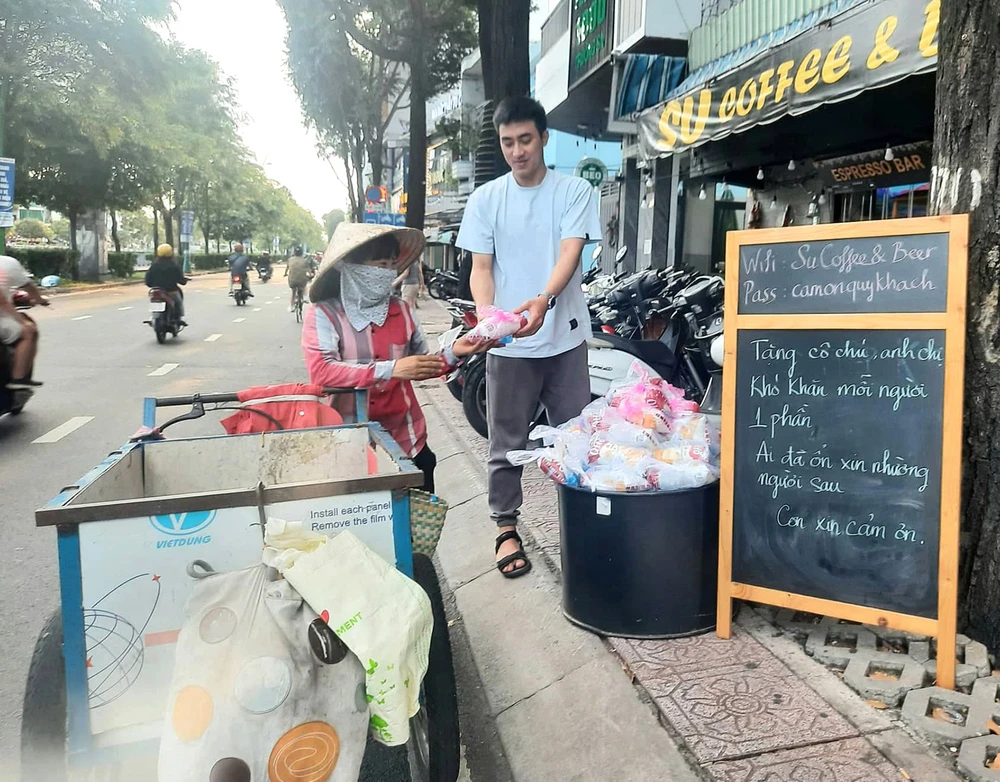 Một tuần 3 lần, quán kê chiếc bàn nhỏ phía trước, bày những túi nhỏ, mỗi túi có chai nước suối ướp lạnh, ổ bánh mì thịt