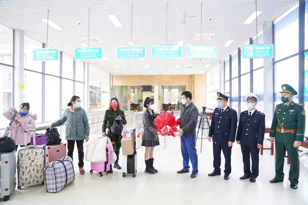 Lãnh đạo Ban Quản lý Cửa khẩu Quốc tế Móng Cái (tỉnh Quảng Ninh) tặng hoa công dân Việt Nam trở về nước. Ảnh: ĐỖ TRUNG