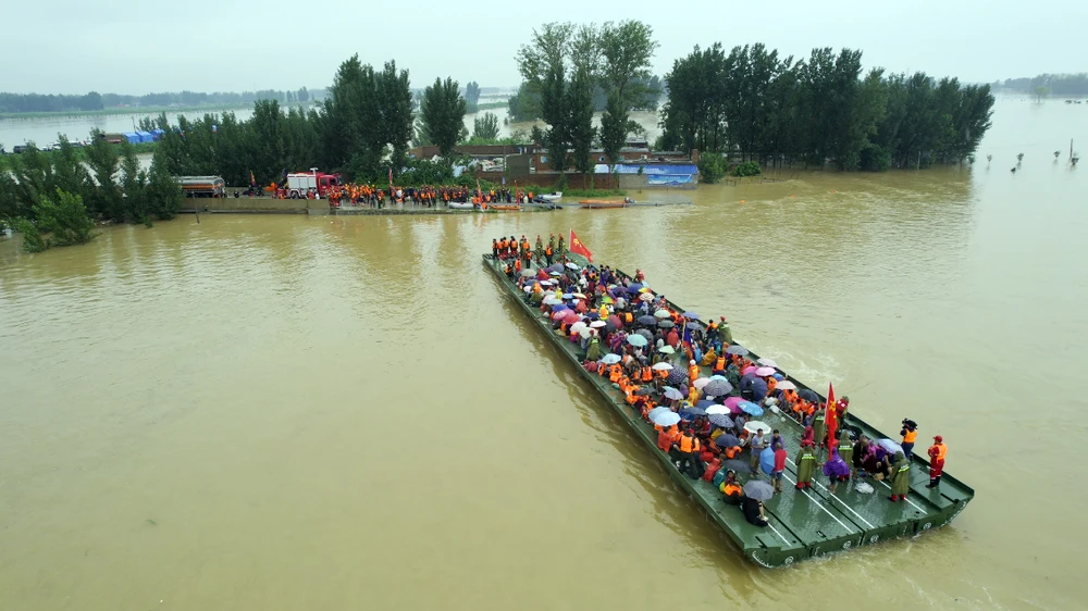 Cầu phao trợ lực giúp người dân di tản khỏi vùng lụt. Ảnh: China Daily