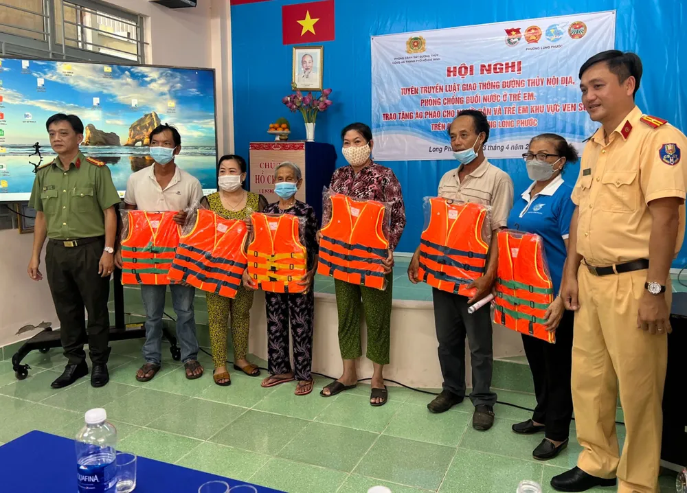 Lực lượng CSGT phát áo phao cho người dân Lực lượng CSGT phát áo phao cho người dân