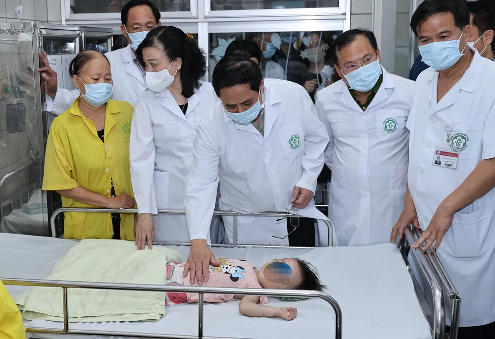 Thủ tướng Phạm Minh Chính thăm hỏi, động viên các nạn nhân vụ cháy tại phố Khương Hạ hiện đang được cấp cứu, điều trị tại Bệnh viện Bạch Mai, Hà Nội. Ảnh: VIẾT CHUNG