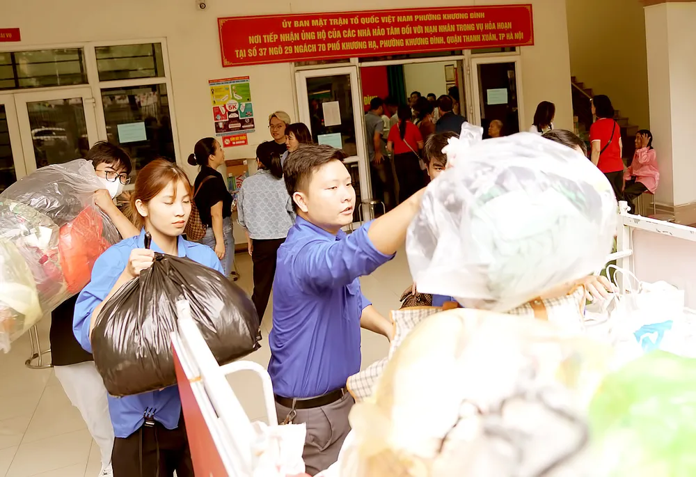 Lực lượng thanh niên hỗ trợ đưa vật phẩm quyên góp về nơi tập kết để phân chia cho các hộ gia đình gặp nạn. Ảnh: ĐỖ TRUNG