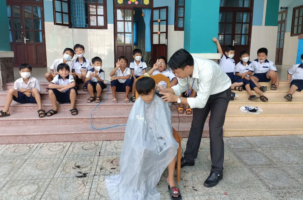 Thầy Lê Hữu Bình, Hiệu trưởng Trường Tiểu học Thạnh An (huyện Cần Giờ, TPHCM cắt tóc cho học sinh ngoài giờ học Thầy Lê Hữu Bình, Hiệu trưởng Trường Tiểu học Thạnh An (huyện Cần Giờ, TPHCM cắt tóc cho học sinh ngoài giờ học