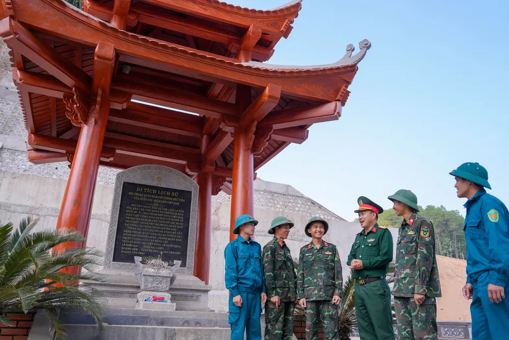 Trung tá Dương Văn Phượng, Chủ nhiệm Chính trị Ban Chỉ huy Quân sự huyện Định Hóa, Thái Nguyên trò chuyện với các chiến sĩ trẻ tại bia tưởng niệm ở Khu di tích đồi Pụ Đồn u4a-8226.jpg