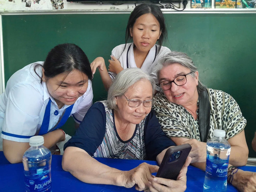 Bà Đoàn Lê Phong (giữa), Phó ban Thường trực Ban Liên lạc cựu tù chính trị và tù binh TPHCM, Phó Chủ tịch Hội Phụ nữ từ thiện TPHCM và các em ở mái ấm do hội phụ trách