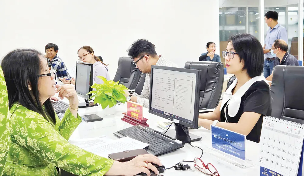 Công chức Trung tâm Phục vụ hành chính công phường Xuân Hòa giải quyết hồ sơ thủ tục hành chính cho người dân trên cổng dịch vụ công. Ảnh: NGÔ BÌNH HANHCHINH.jpg