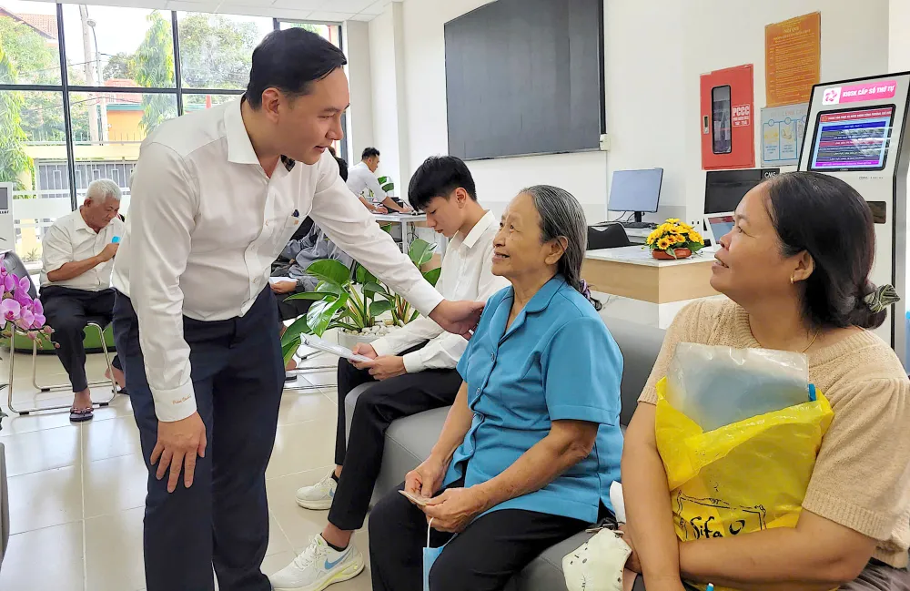 Bí thư Đảng ủy phường Thủ Đức Mai Hữu Quyết trò chuyện với người dân tới làm thủ tục hành chính tại Trung tâm Phục vụ hành chính công phường. Ảnh: PHƯƠNG UYÊN phuongthuduc.jpg