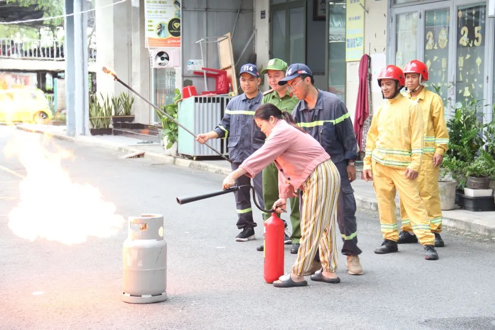 Người dân trải nghiệm dùng bình chữa cháy dập lửa. Ảnh: TÂM TRANG chuachay.jpg