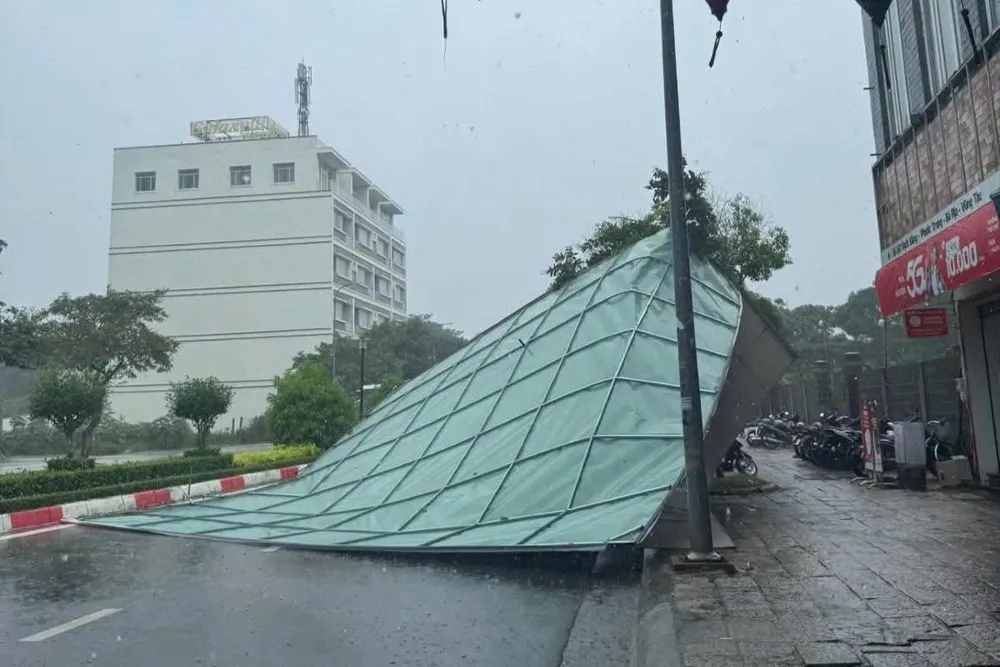 Một bảng hiệu lớn trên đường Bạch Đằng (phường Bà Rịa) bị dông lốc giật văng ra đường vào chiều 20-7. Ảnh: THÀNH AN giong loc.jpg
