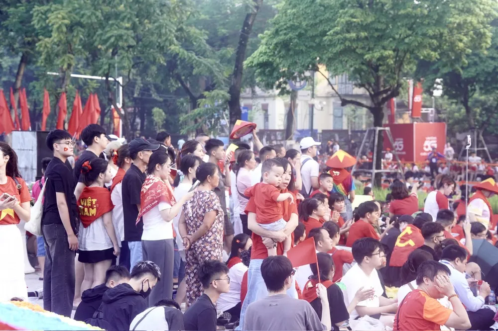 Người dân tập trung ở đường Điện Biên Phủ chờ xem trực thăng mang cờ và biểu diễn của Su-30MK2. Ảnh: TIẾN CƯỜNG dgdienbienphu.jpg